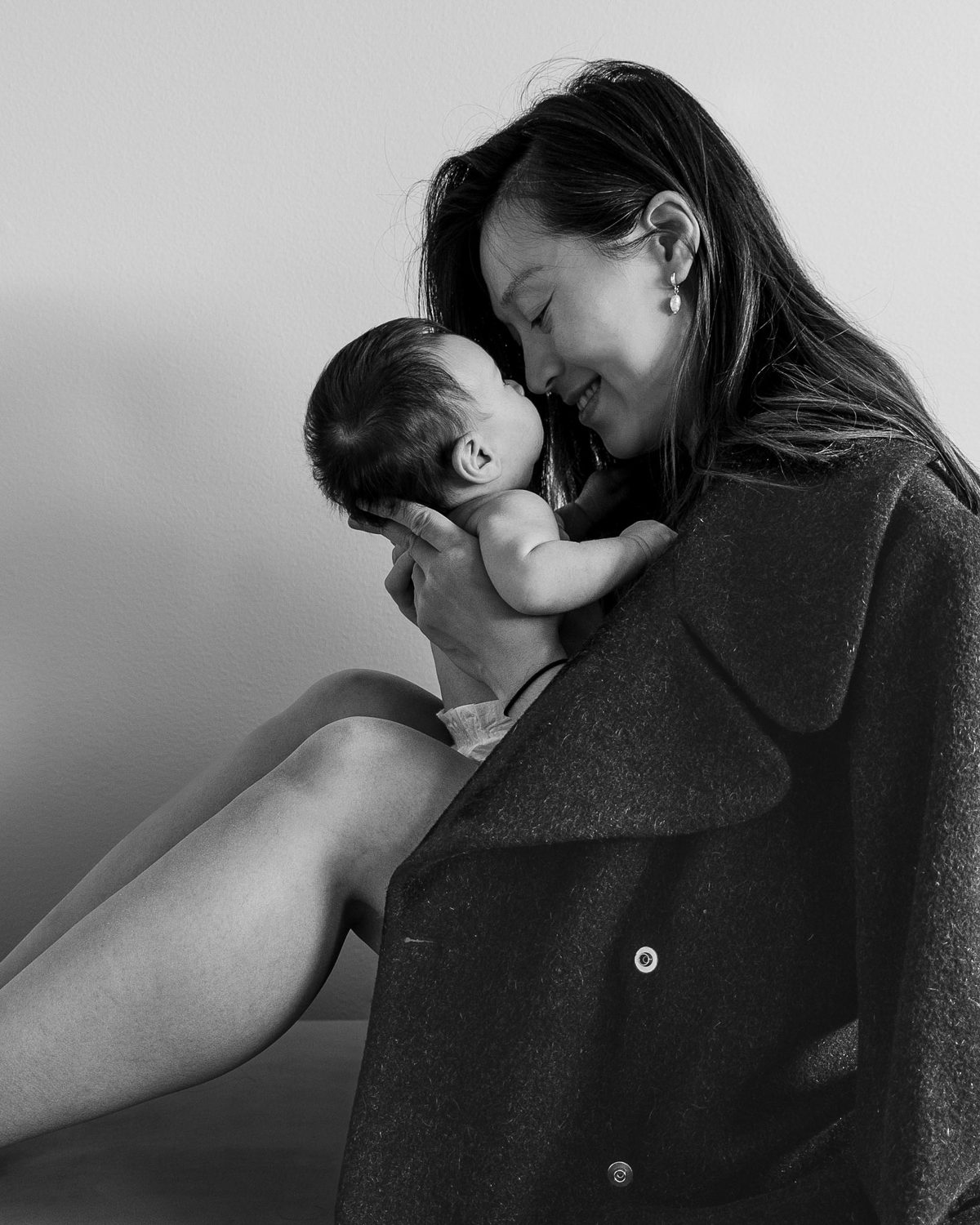 Mother holding her newborn close, nose to nose